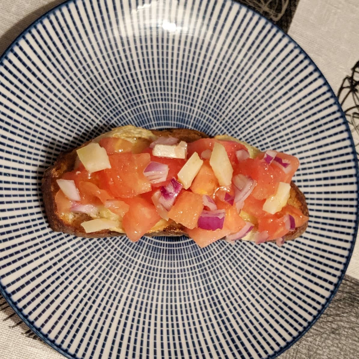 Bruschetta de tomate, cebolla de Figueres y queso manchego con base de rulo de cabra y pan Turris