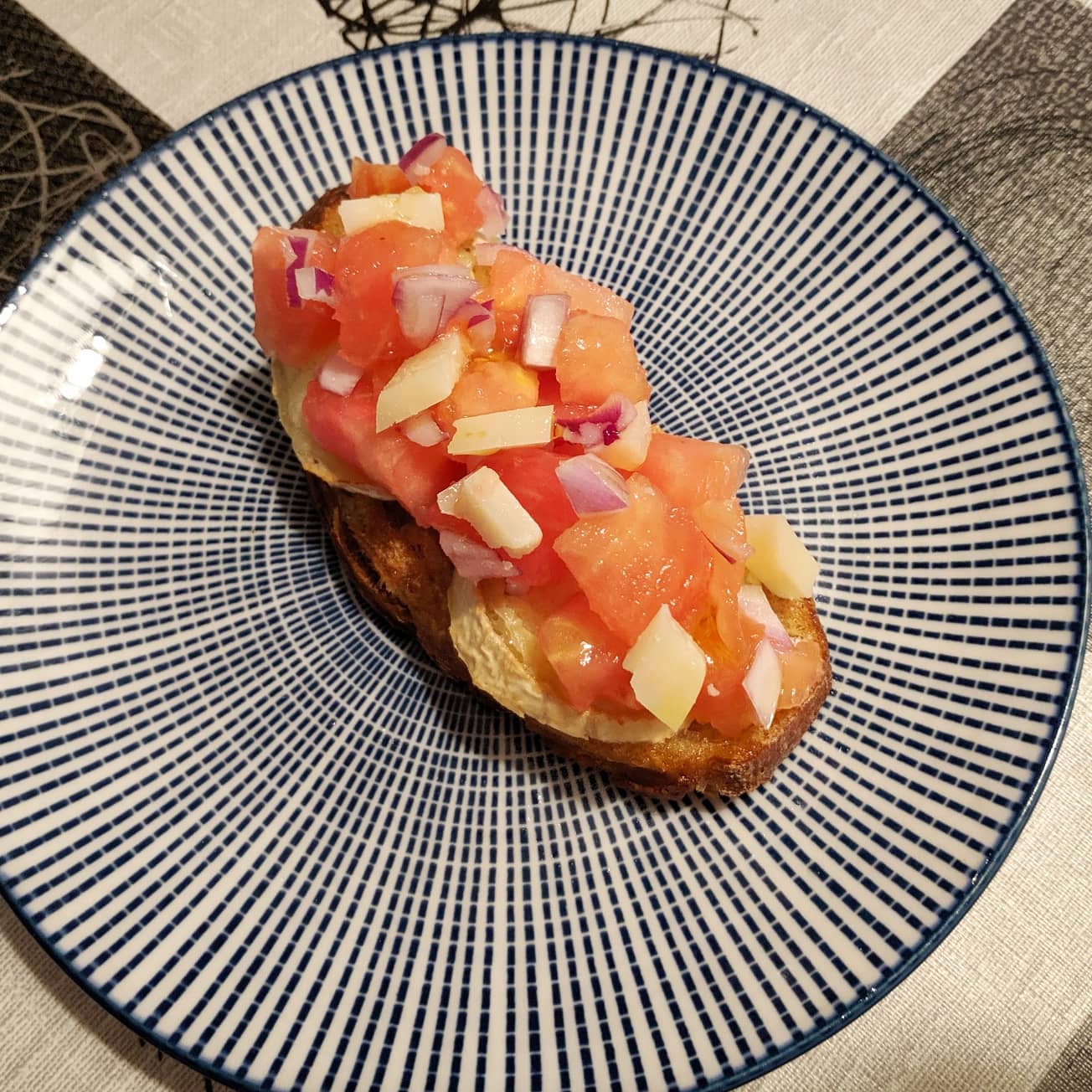Bruschetta de tomate, cebolla de Figueres y queso manchego con base de rulo de cabra y pan Turris