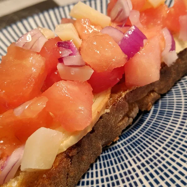 Bruschetta de tomate, cebolla de Figueres y queso manchego con base de rulo de cabra y pan Turris