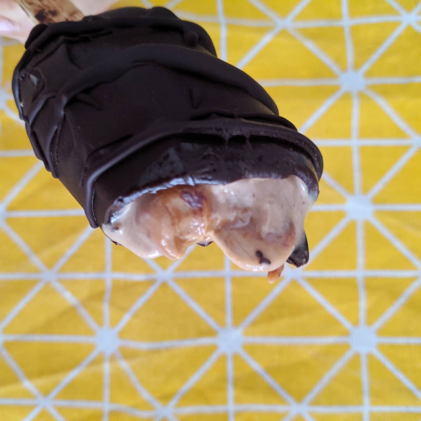 Helado de banana, cacao y crema de cacahuete con cobertura de chocolate negro