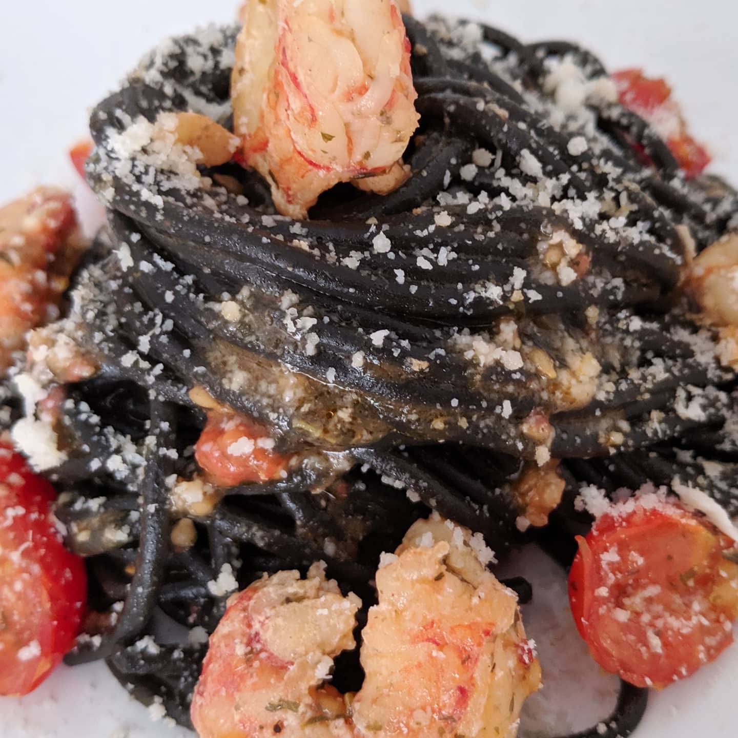 Spaghetti nero di seppia con gambón, cherrys y parmesano